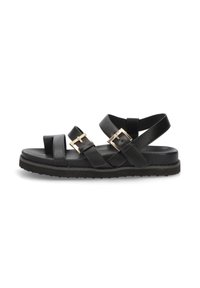 Sandalias negras de material sintético. Con correas cruzadas y suela plana, con detalles de hebilla en tono dorado y plantilla texturada.