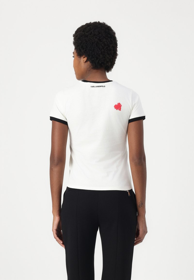 Weißes Kurzarm-T-Shirt mit schwarzem Besatz und einem roten Pinselstrich-Design auf dem Rücken, mit dem Text "KARL LAGERFELD." Aus weichem Baumwollmaterial.