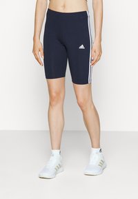 Marineblauwe fietsbroek met wit drie-strepen ontwerp, gemaakt van rekbaar materiaal. Inclusief klein wit logo aan de voorkant links.