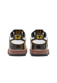 Låga sneakers med överdel i svart, gult och vitt. Har glänsande material, panda-logga på hälen och en brun gummisula.