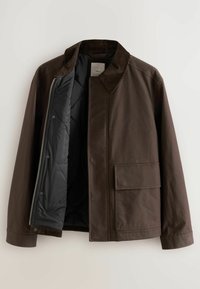 Chaqueta marrón con collar de pana, forro negro acolchado y un gran bolsillo frontal. Tela exterior suave con diseño estructurado.