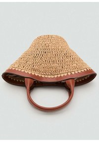 Woven straw tote bag with brown faux leather accents and handles. Rounded bell shape with scalloped edges, highlighting intricate weave pattern.