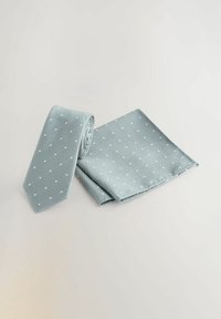 Helle blaue Krawatte und passendes Taschentuch, beide mit weißen Punkten. Aus strukturiertem Stoff, ordentlich gefaltet, zeigt ein schlankes Design.