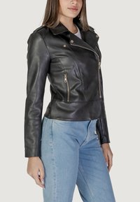 Giubbotto da moto in pelle nera con chiusura lampo frontale, spalline prominenti e due tasche laterali con zip. Si adatta bene in vita.