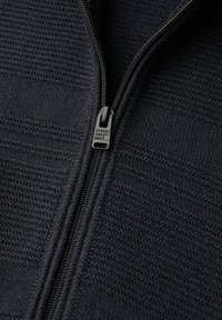 Chaqueta azul oscuro con cremallera, hecha de tela texturizada, con un tirador de cremallera visible con la marca "STREET ONE MEN". Diseño simple y estructurado.