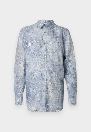 Kék denim ing virágmintával, hosszú ujjal, gallérral és elülső zsebekkel. Csillogó ezüst gombokkal rögzítve. Sima textúra.