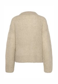 Pull beige en tricot avec un design court, manches larges et finition texturée. Il présente un col arrondi et une taille côtelée.