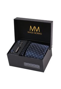 Cravate à pois navy, pince à cravate en argent et boutons de manchette assortis, présentés dans une boîte noire texturée avec des lettres dorées et une fenêtre transparente.