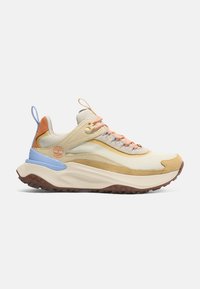 Beige och tan sneakers med en strukturerad textilöversida, orange och blå accenter, snören med flerfärgad detaljer och en tjock, robust sula.