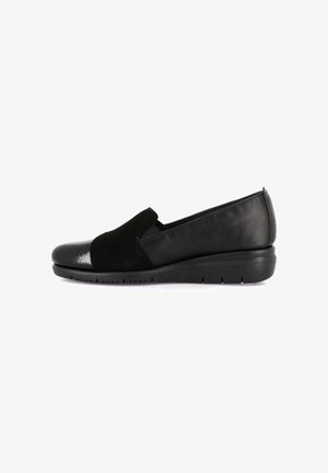 Scarpa slip-on nera da donna con tacco a zeppa basso, retro in pelle liscia, parte centrale in camoscio e punta testurizzata su sfondo bianco.