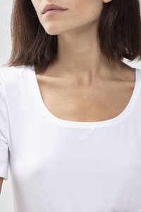 Biała koszulka z krótkim rękawem o szerokim dekolcie w kształcie łódki. Materiał jest gładki i lekki, prezentując luźny krój wokół kołnierza i ramion.