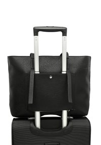 Black leather tote bag with a textured finish, fitted over a black suitcase with a retractable silver handle. Features top handles and a front pocket.