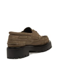 Zapato náutico de ante marrón con suela de goma negra gruesa, detalles de cordones y costuras en contraste. Diseño de puntera redonda.