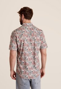 Korte mouw shirt met een roze achtergrond en een bladerenpatroon in groen en blauw, gemaakt van lichtgewicht stof met een ontspannen pasvorm.