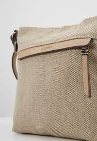 Beige texturerad tygväska med läderdetaljer och dragkedjeficka. Har Esprit-logotyp präglad på lädret. Mjuk, strukturerad design.
