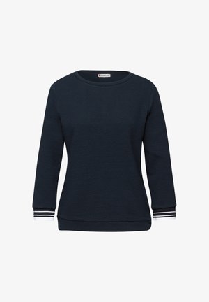 Pull bleu marine texturé à manches longues avec encolure ronde et poignets blancs ornés de rayures noires sur fond blanc.