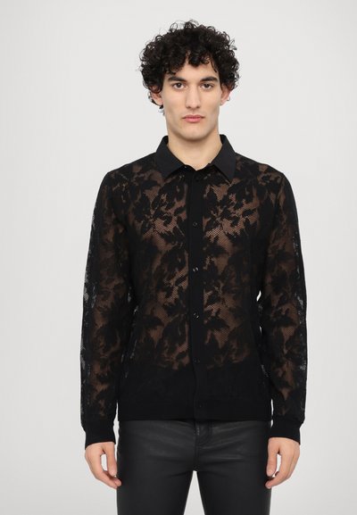 Schwarze Spitzenbluse mit langen Ärmeln, die ein florales Muster aufweist, mit Knopfverschluss, kontrastierendem einfarbigen schwarzen Kragen und Bündchen sowie transparenter Textur.