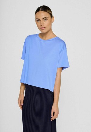 Lichtblauw, cropped t-shirt van zacht materiaal met een ronde halslijn en korte mouwen, gecombineerd met een marineblauwe, geribbelde rok.