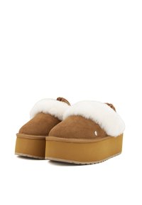 Pantofole in suede marrone con zeppa e foderate in finta pelliccia bianca, punta arrotondata e fiocco decorativo sul retro. Presentano una robusta suola in gomma.