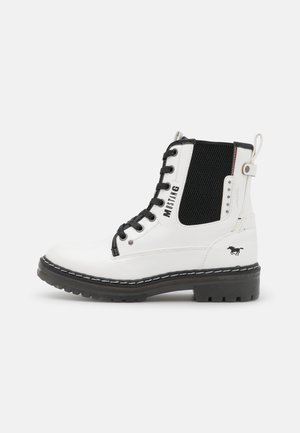 Bottine en cuir blanc avec lacets noirs, empiècement latéral élastique noir, semelle noire et inscription "Mustang" accompagnée du logo cheval.