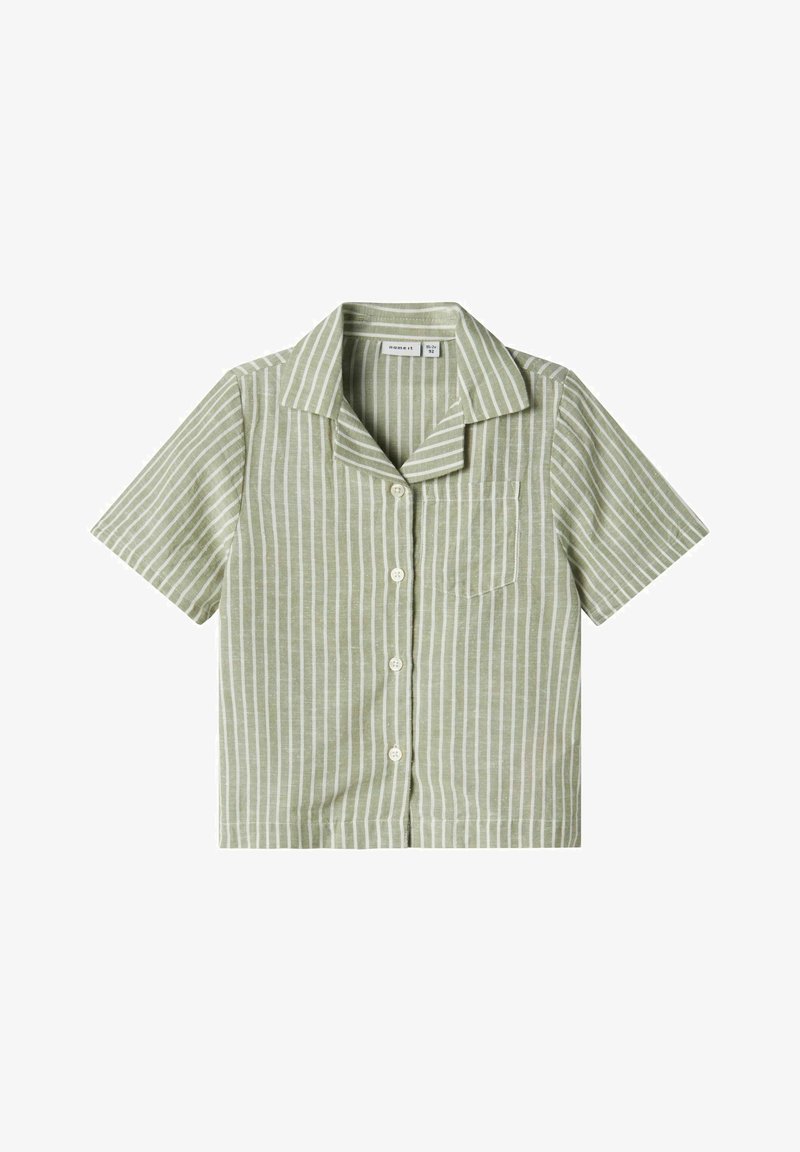 Camicetta a maniche corte di verde chiaro con righe verticali bianche, chiusura frontale con bottoni e una tasca sul petto. Realizzata in tessuto morbido.