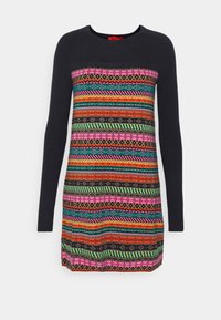 Robe-pull noire à manches longues avec des rayures horizontales colorées et des motifs géométriques en rose, vert, orange, jaune et bleu.