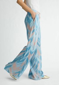 Leichte, fließende Palazzo-Hosen in Blau und Pastellrosa mit einem Zickzackmuster. Verfügt über seitliche Taschen und einen lockeren Schnitt.