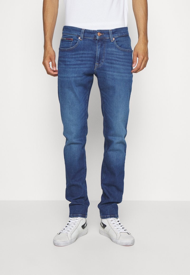 Mörkblå denimjeans med rak passform, fem fickor och subtil blekning. Har knappgylft och liten logodetalj på bakfickan.