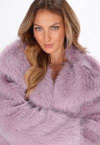 Lavender nepbont wrap met lange, zachte vezels; brede kraag; subtiele glans; gelaagde textuur versterkt de visuele diepte.