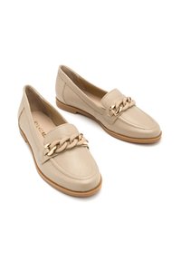 Beżowe skórzane mokasyny o teksturowanym wykończeniu, z złotym łańcuszkiem na przodzie i gładką gumową podeszwą.