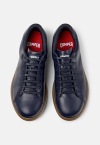 Sneakers in pelle blu con punta tonda, suola in gomma piatta e lacci texturizzati. Presentano solette rosse con il logo "CAMPER" su ciascun linguetta.