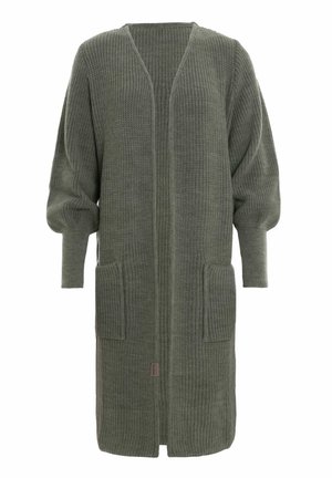 Lang, olijfgroene gebreide cardi met open voorkant, twee voorzakken en puffed lange mouwen die taperen bij de polsen.