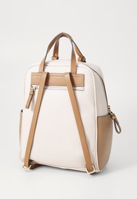 Rucsac cu un corp din piele ecologică albă texturată și accente beige, dotat cu două curele pentru umeri, o mânere superioară și un buzunar cu fermoar.