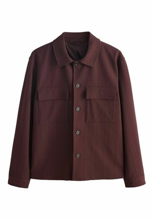 Mørkebrun skjortejakke med lange ærmer, to forlommer med klap og et struktureret stofmønster.