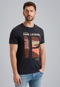 Crna pamučna majica s grafičkim dizajnom u toplim tonovima, s natpisom "PME LEGEND" i apstraktnim oblicima. Ležeran kroj s kratkim rukavima.