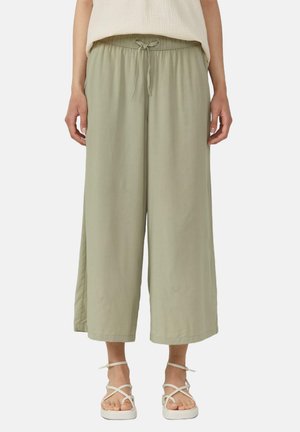 Pantalons larges vert clair en tissu doux avec une taille élastique et un cordon de serrage, présentant une coupe décontractée et des fentes latérales.