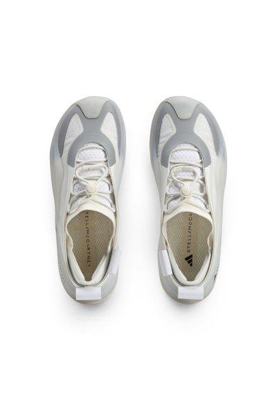 Könnyű sportcipők fehér és szürke színben, légáteresztő hálós felsőrésszel, rugalmas fűzőkkel és kialakított gumitalppal, hangsúlyos részletekkel.