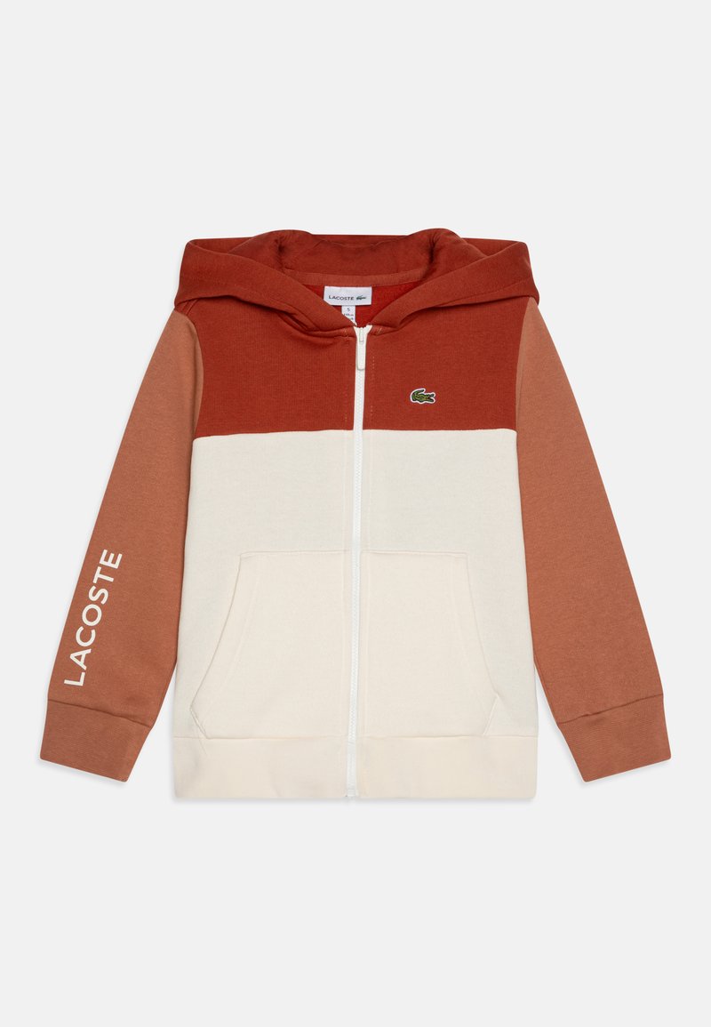 Hooded zip sweatshirt featuring a color-block design in orange, beige, and light brown, with a Lacoste logo on the left chest and sleeve.