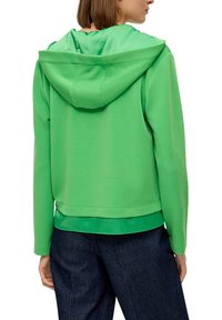 Zielona bluza z kapturem z regulowanym sznurkiem, prążkowanymi mankietami i gładką teksturą. Posiada luźny krój i skrócony fason.