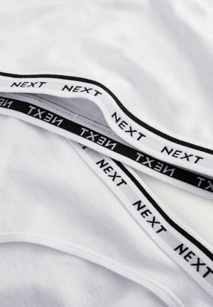 Valkoinen puuvillakangas mustalla elastisella nauhalla, jossa on "NEXT"-teksti. Sileä rakenne, pyöristetyt reunat ja kerroksellinen muotoilu.