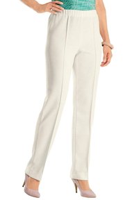Witte geribde elastische tailleband broeken met een rechte snit, gecombineerd met lichtroze hoge hakken. Glad textuur, minimale details en een aansluitend ontwerp.