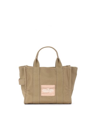 Pequena bolsa tote de lona bege com alças duplas e etiqueta em patch frontal com texto branco, em pé sobre um fundo branco.