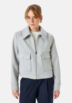Chaqueta de mezcla de lana gris con cremallera frontal, cuello oversize, dos bolsillos de parche con cierres a presión y puños acanalados.