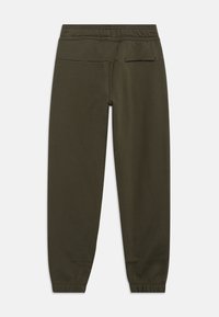 Tumši zaļas elastīgas jostasvietas sporta bikses ar aprocētām potītēm un vienu aizmugurējo kabatu labajā pusē, redzamas no aizmugures.