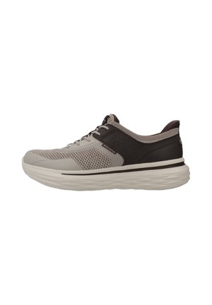 Zapatilla deportiva en gris claro y negro con parte superior de malla, cierre de cordones, cuello acolchado y suela blanca gruesa.