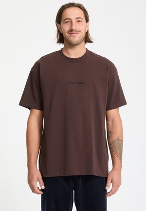 Brązowa koszulka z krótkim rękawem z bawełny, z okrągłym dekoltem, z czarnym logo "VOLCOM" haftowanym na klatce piersiowej.