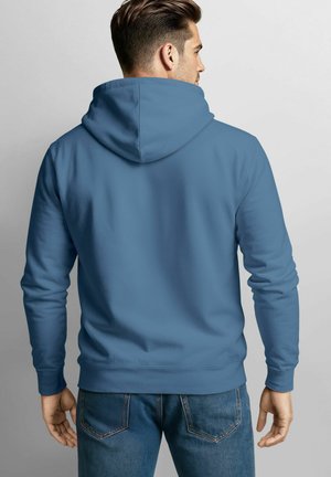 Hellblauer Hoodie mit einer geräumigen Kapuze, glatter Textur und gerippten Bündchen. Verfügt über einen geraden Saum und eine lockere Passform, kombiniert mit blauen Jeans.