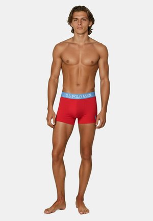 Red boxer shorts with a light blue waistband featuring "U.S. POLO ASSN." in bold lettering. Sleek, form-fitting design, cotton material.