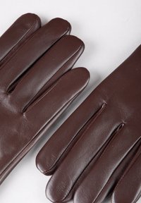 Brown leather gloves with a smooth texture, featuring five elongated fingers and tailored stitching along the edges. No visible hardware.