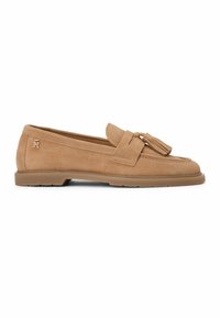 Mocassin en daim camel avec détail de pampille, semelle en caoutchouc basse et petit logo métallique sur le côté du talon.